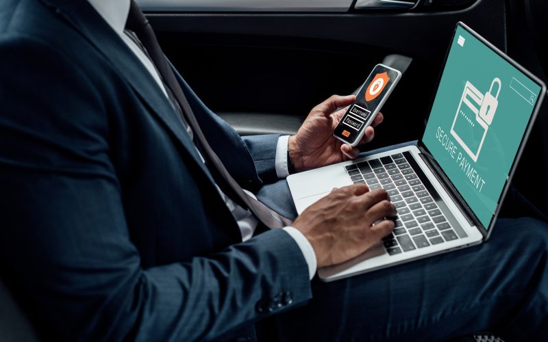 cropped-view-of-african-american-businessman-using-laptop-and-smartphone-in-car-with-cyber-security.jpg